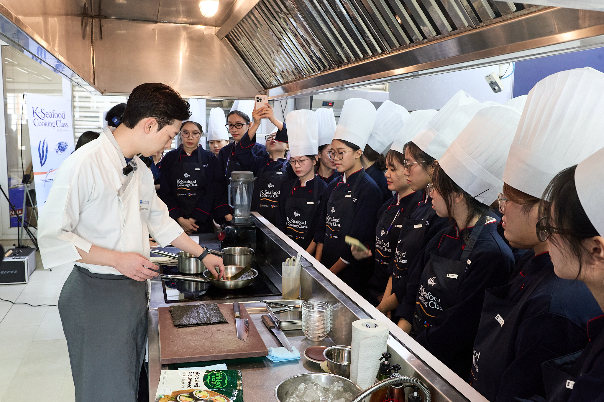 Chef Chan-yang Lee is demonstrating dishes made with K-Seafood at a cooking class held at Thang Long University