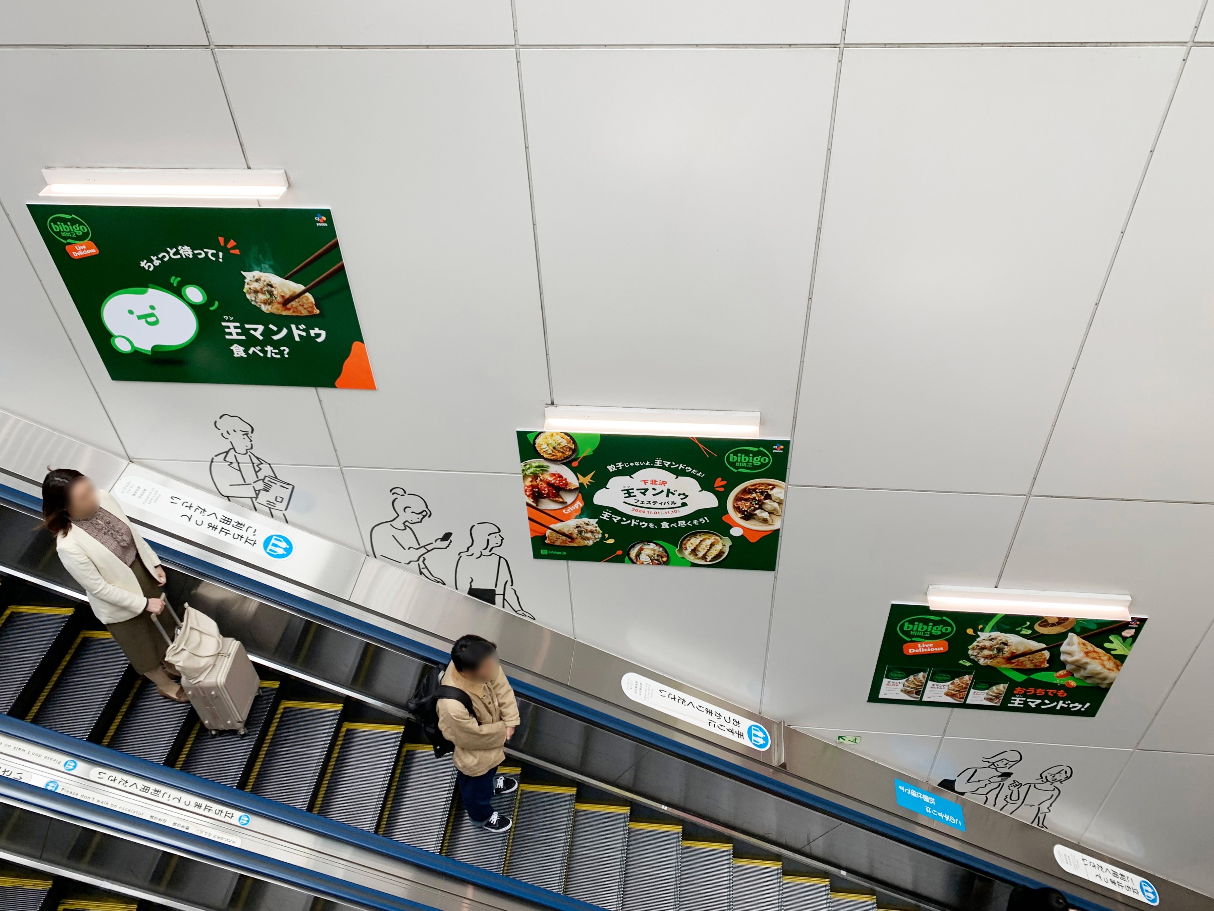 bibigo ads running along an escalator in a Japanese metro station