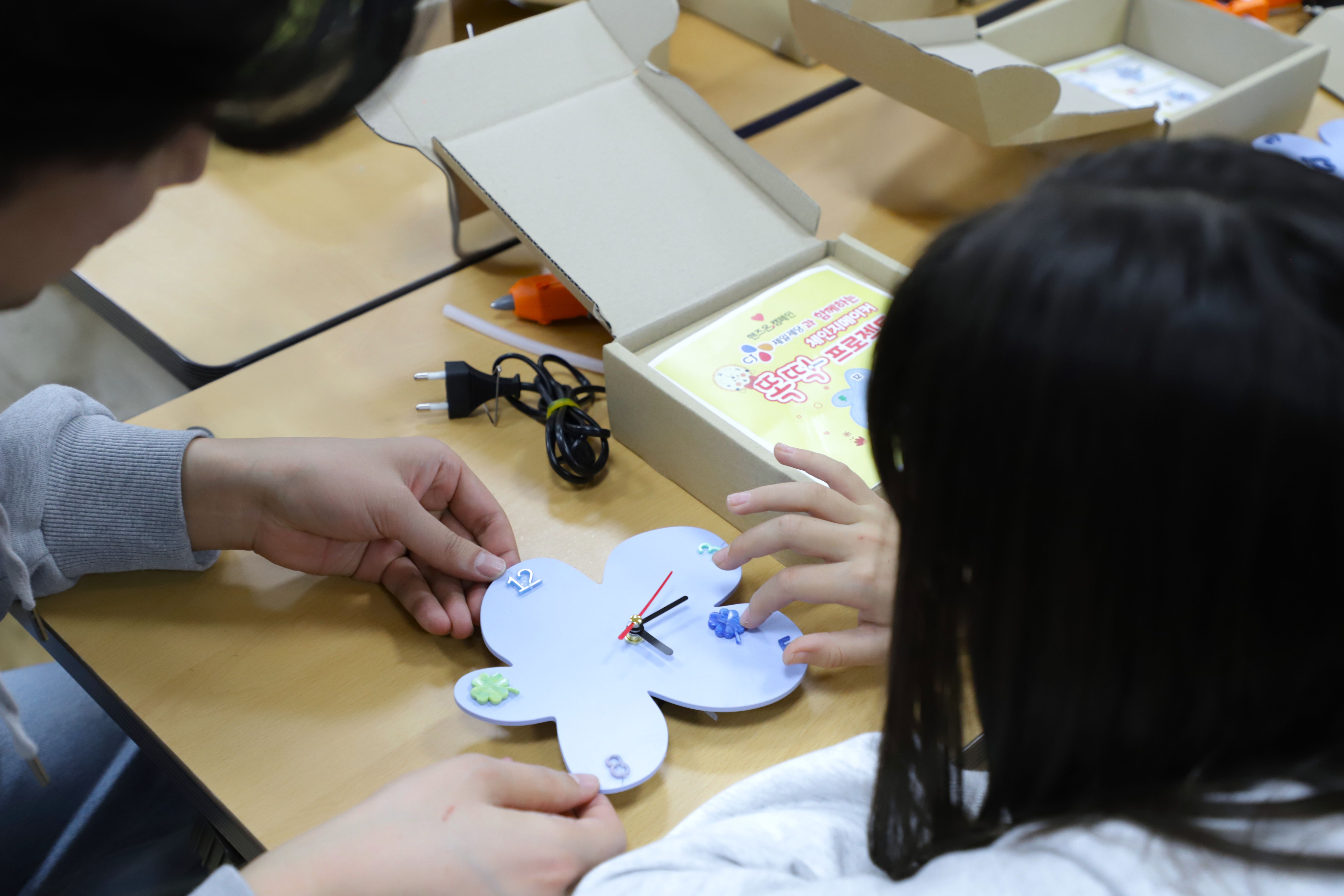 햇반 용기로 만들어진 시계 키트를 직접 조립한 아이들
